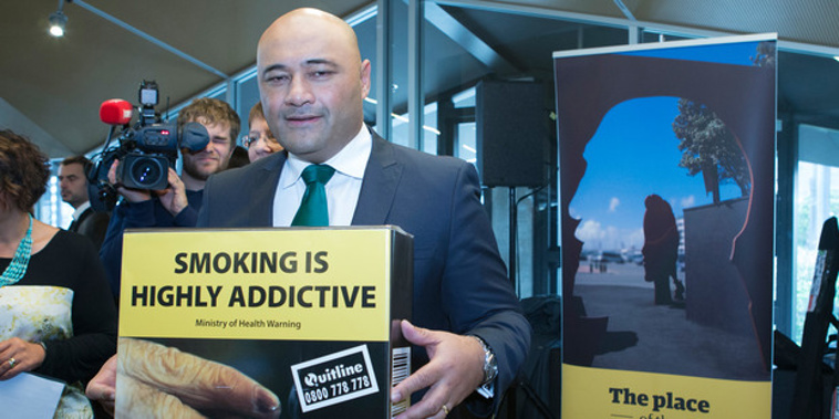 Associate Health Minister Sam Lotu-Iiga with an example of the new plain-packaging cigarette packet at the announcement in Wellington. Photo / Mark Mitchell