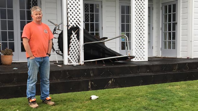 Shane Aberdein with the trampoline that was blown into his house (Josh Price)