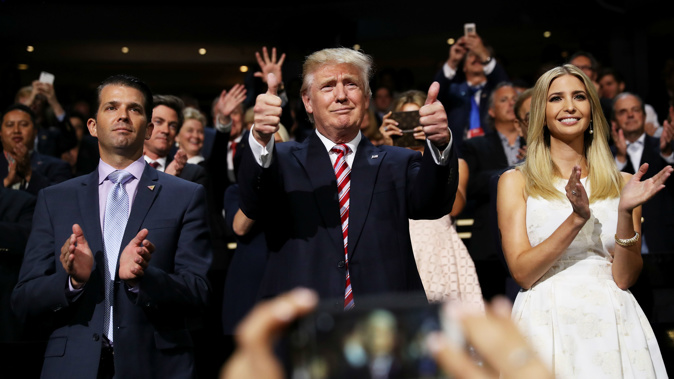 Donald Trump (C) gives two thumbs up as Donald Trump Jr. (L) and Ivanka Trump (R) stand and cheer for Eric Trump as he delivers his speech during the third day of the Republican National Convention on July 20, 2016 (Getty Images)
