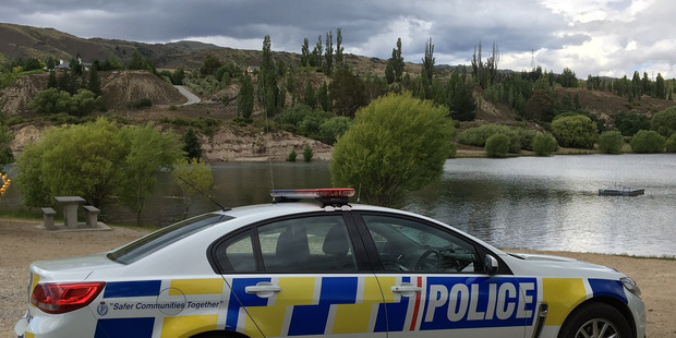 A police car at the Bannockburn inlet after a man got into trouble at Lake Dunstan on Saturday. Photo / Otago Daily Times