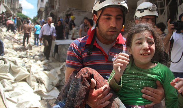 An injured girl and a rescue worker in Aleppo after a bomb blast (Getty Images)