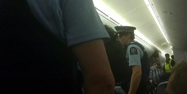 Police on board the flight dealing with the abusive passenger (Supplied) 
