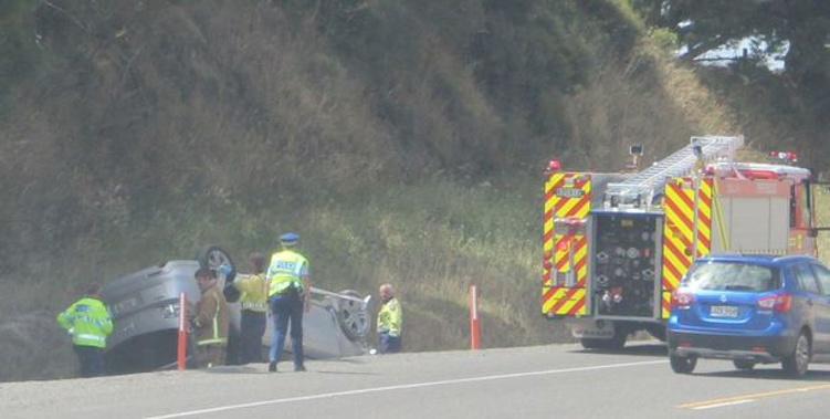 Police and fire brigade members attend a motor vehicle accident on State Highway 2.