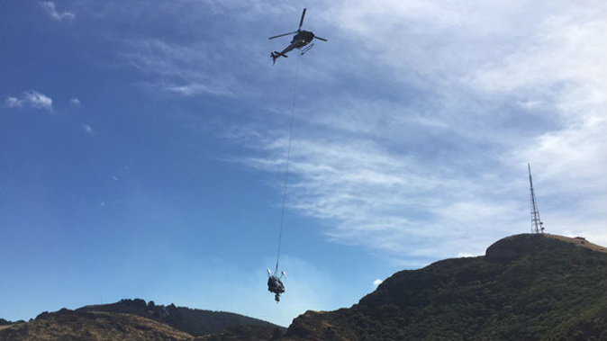 The main fuselage being airlifted out of a steep gully under the Sugarloaf. Photo / TAIC