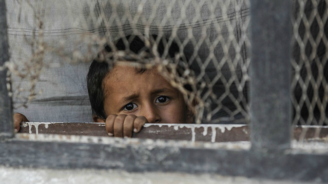 A boy looks out from a window of his home in the border town of Jarablus, Syria. (Getty)