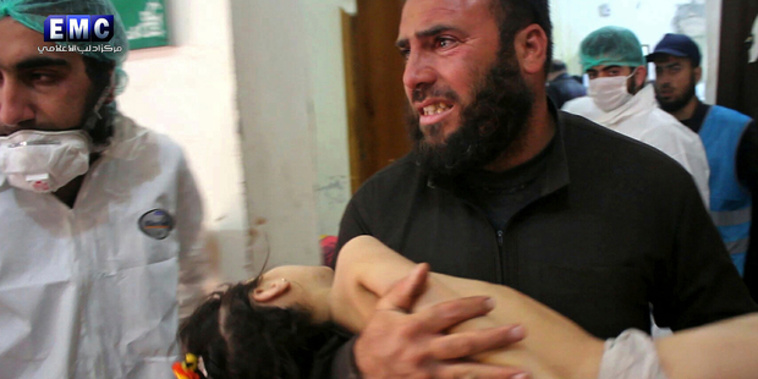 A man carrying a child following a suspected chemical attack. Photo / AP
