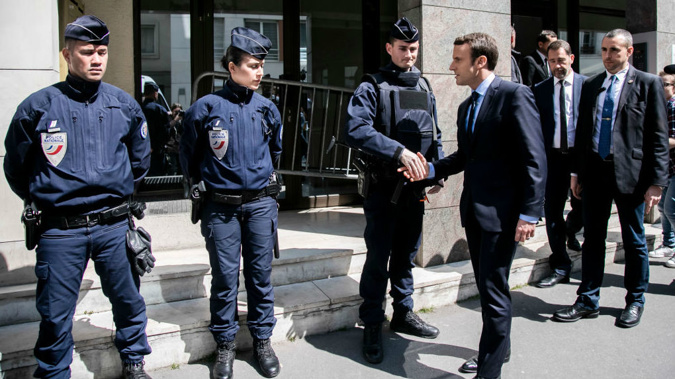 Emmanuel Macron greets police outside his Campaign Headquarters after a police officer was killed during a shooting on the Champs Elysees' avenue. (Getty)