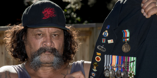 Manu Toko sits with his father's medals. (Brett Phibbs)