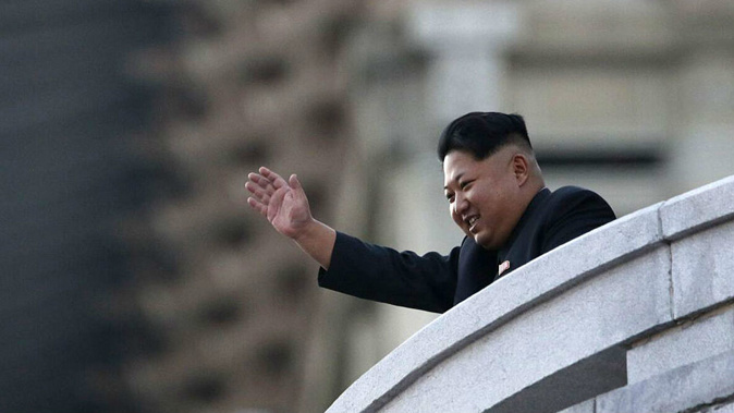 North Korea's leader Kim Jong-Un waves from a balcony towards participants of a mass military parade at Kim Il-Sung square. (Getty)