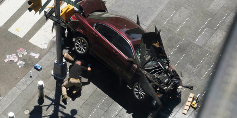 A police officer inspects the car crash in New York's Times Square. (AP)