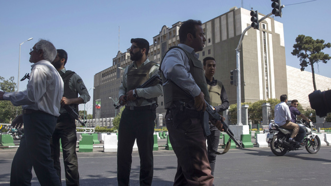 Police officers stand outside Iran's parliament building following an attack by several gunmen (Getty Images)