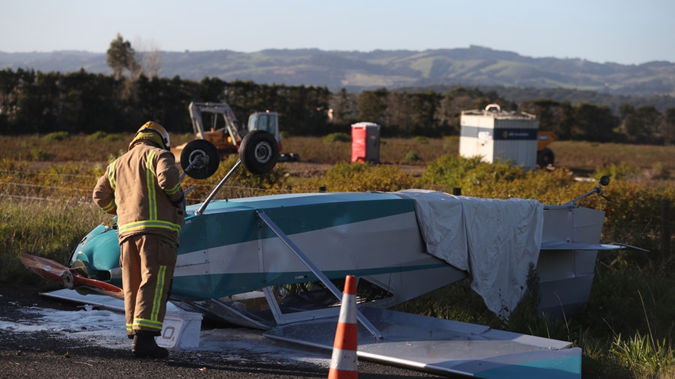 A fireman inspects the wreckage of the light plane that crashed on Runciman Road in Pukekohe East. (Jason Oxenham)