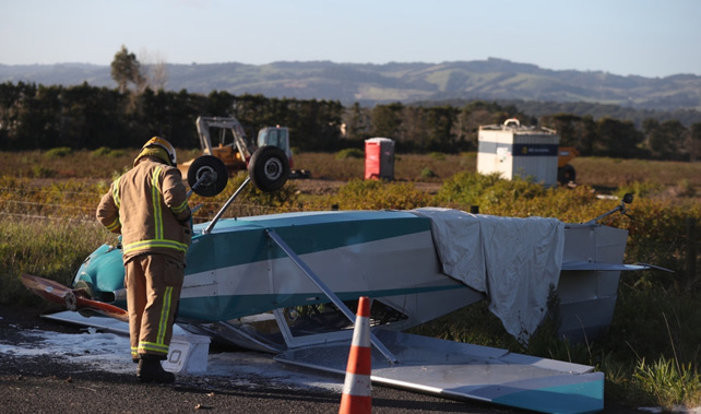 A fireman inspects the wreckage of the light plane that crashed on Runciman Road in Pukekohe East. (Jason Oxenham)