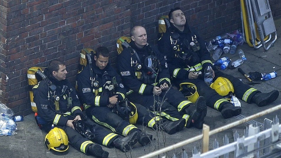 Firefighters rest as they take a break. Photo / AP