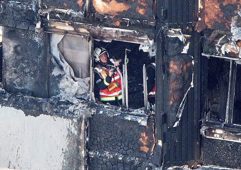 A firefighter investigates a floor after a fire engulfed the 24-storey Grenfell Tower. Photo / AP