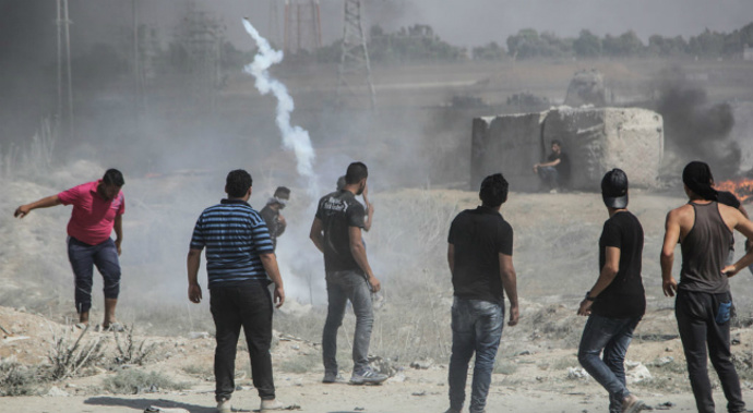 Palestinian protesters gather during clashes with Israeli troops near the border between Israel and central Gaza Strip. (Getty)