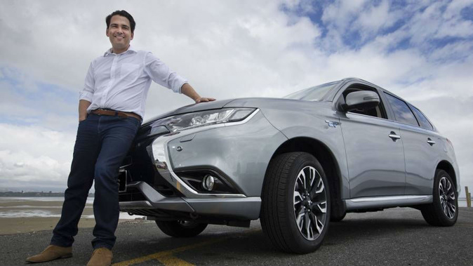 Transport Minister Simon Bridges, pictured with his Mitsubishi Outlander PHEV plug-in hybrid, says the Government won't follow the UK in banning petrol and diesel cars from 2040. (Photo / file)