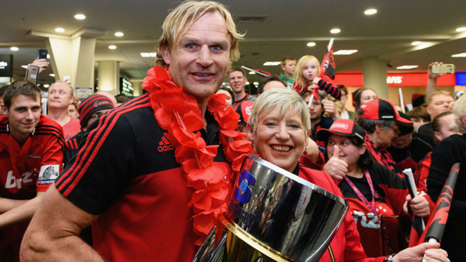 Head Coach Scott Robertson of the Crusaders and Christchurch Mayor Lianne Dalziel (L-R) pose with the Super Rugby trophy during the Crusaders arrival at Christchurch Airport. (Photo \ Getty Images)