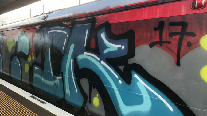 A video has captured a group spraypainting graffiti on a train at Baldwin Avenue Railway Station in Auckland.