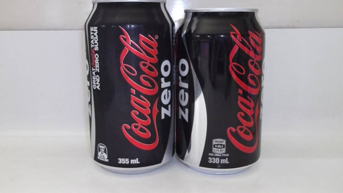 The size difference between the old 355ml can of coke in a pack and the new 330ml size. (Photo / Supplied)