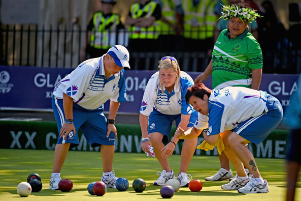 LAWN BOWLS: Scotland’s team get excited while a Cook Islands player watches on (Getty Images)