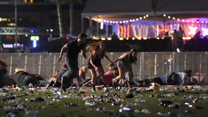 People run from the Route 91 Harvest country music festival after gun fire was heard yesterday. (Photo / AP)