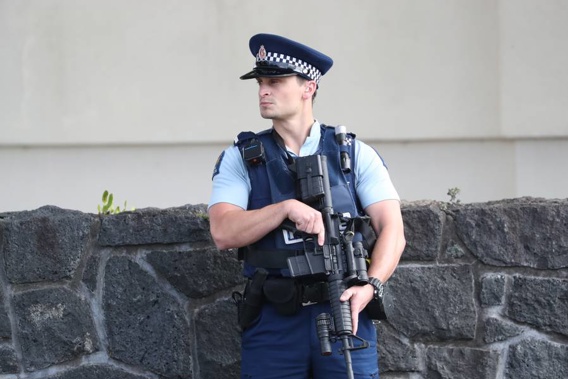 An armed police officer stands guard in Greenlane. (Photo / Jason Oxenham)