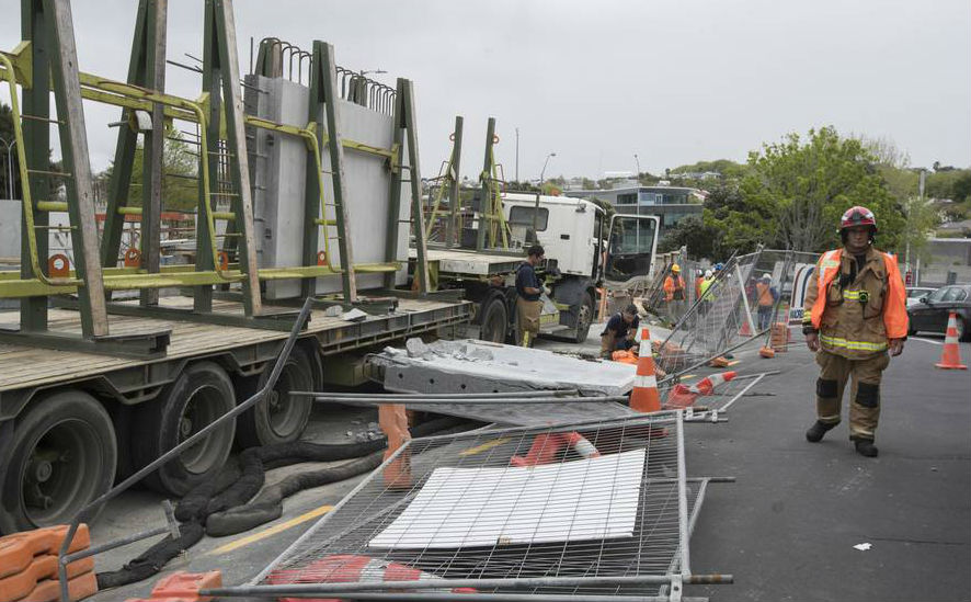Firefighters attend to an injured worker after a concrete slab fell from a truck, narrowly missing him. (Photo / Brett Phibbs)