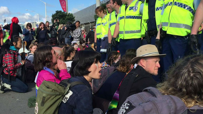 At one point, about 50 police officers swooped in to move protesters out of the way so a bus load of delegates could get in. (Photo \ NZ Herald)