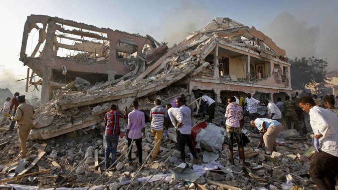 Somalis gather and search for survivors by destroyed buildings at the scene of a blast in the capital Mogadishu, Somalia. (Photo / AP)