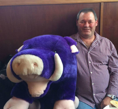 Bruce Smith poses with a pig soft toy. Photo/Facebook