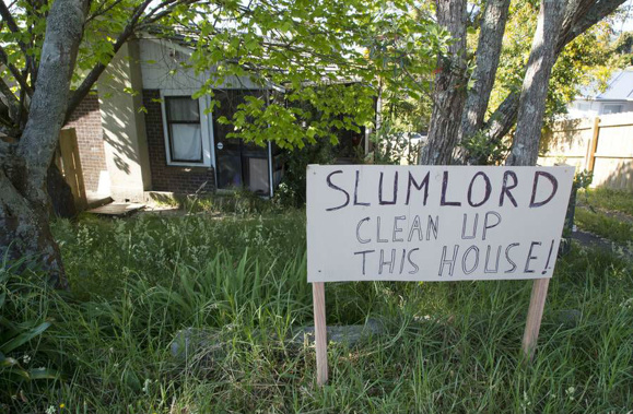 The sign erected in the overgrown grass outside a Golf Rd rental which neighbours say needs to be cleaned up. (Photo / NZ Herald)