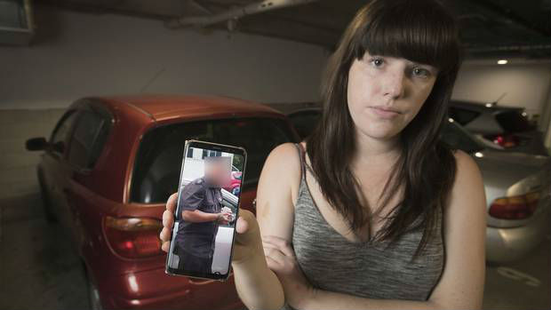 Holly Ryan was halfway in her car when a private parking enforcer (pictured on her phone) clamped her wheel. (Photo / Greg Bowker)