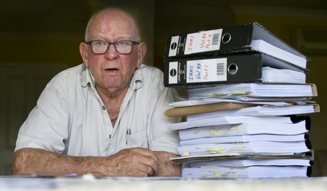 Brian Arndt pictured at home in Matamata with the huge pile of paperwork that he has accumulated over the years. (Photo / NZ Herald)