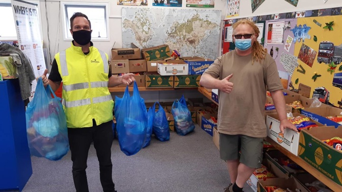 Cameron Webb (left), general manager operations for Deejays, and Randwick Park resident Dave Tims get food parcels ready for tomorrow's vaccination centre. (Photo / Supplied)