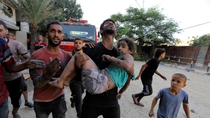 Palestinians carry a wounded girl after being rescued from under the rubble of buildings that were destroyed by Israeli airstrikes in Jabaliya refugee camp, northern Gaza Strip. Photo / AP