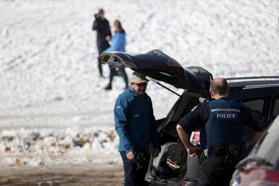Police speaking to people showing up at the summit of the Crown Range Rd to play in the snow. Under level 4 lockdown rules people are meant to stay home. (Photo / George Heard)