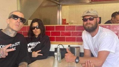 A-lister couple Travis Barker and Kourtney Kardashian posing with a customer at Wise Boys Grey Lynn.
