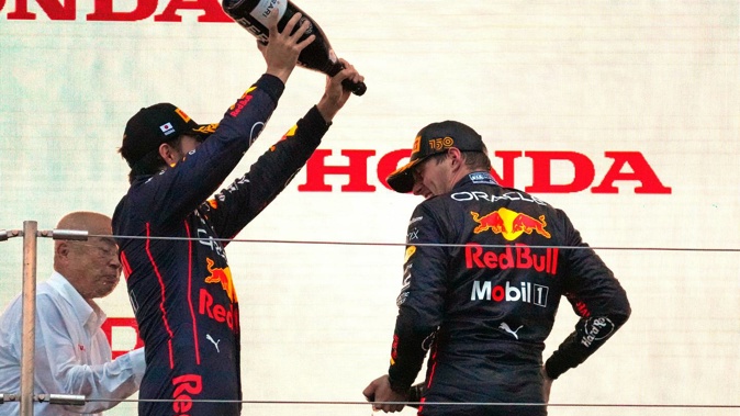 Red Bull driver Max Verstappen is sprayed with champagne by second placed teammate Sergio Perez on the podium during the Japanese Grand Prix. Photo / AP