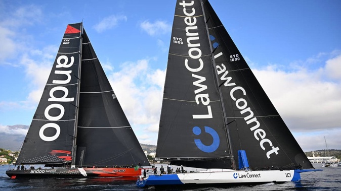LawConnect moves ahead of Andoo Comanche near the finish of the 2023 Sydney to Hobart today on the Derwent River to take line honours. Photo / Getty Images