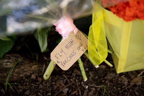 Hand-written notes, flowers and soft toys were placed in a row outside the house where the baby was injured. (Photo / Dean Purcell)