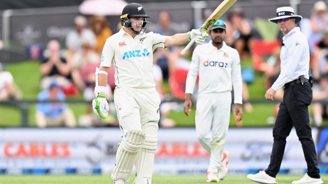 Tom Latham raises his bat after reaching a half century during day one of the second test. Photo / Getty