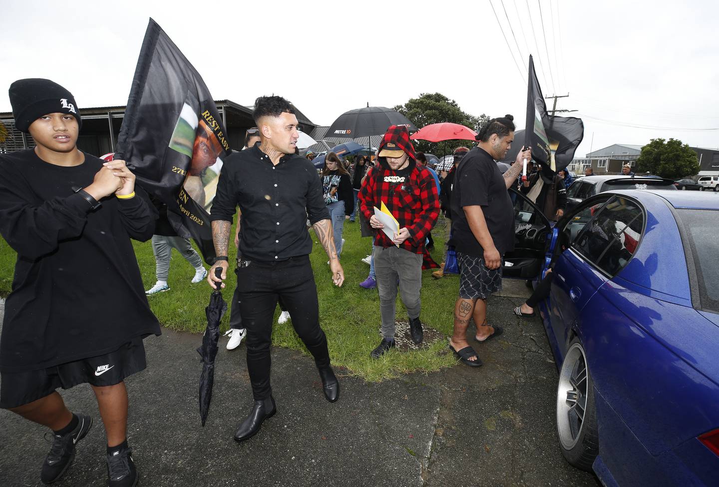 Shayden Perkinson's loved ones, alongside hīkoi organiser Zee Tana, wave flags in the late man's honour. Photo / Michael Cunningham