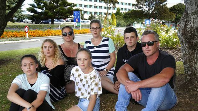 James Bretherton's sisters Michelle Taikato and Taralee McNeil with brother Ricky Bretherton (far right) and extended family take a breather outside Whanganui Hospital. Photo/ Bevan Conley