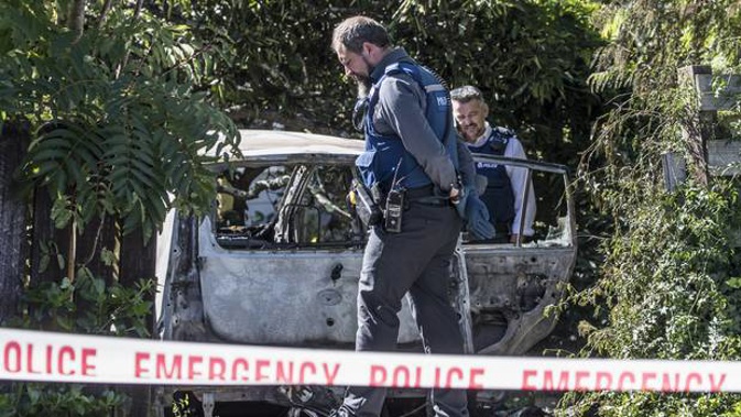 Police investigate the car fire in a driveway at Bayside Ave in Te Atatu, Auckland. A badly burned woman was taken to Auckland Hospital. (Photo / Greg Bowker)