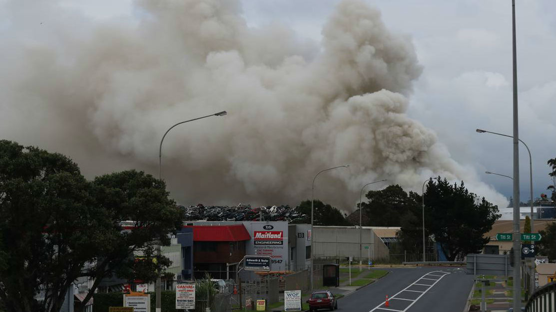 Firefighters are still battling to extinguish a huge fire at an Auckland scrap metal plant. (Photo \ NZ Herald)