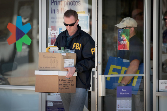 FBI agents collect evidence at a FedEx Office facility following an explosion at a nearby sorting center in Texas. (photo \ Getty Images)