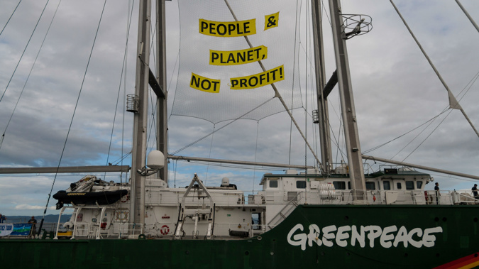  A Greenpeace boat with a banner reads 'People & Planet, Not Profit!' seen near the Shell Gas refinery. (Photo \ Getty Images)