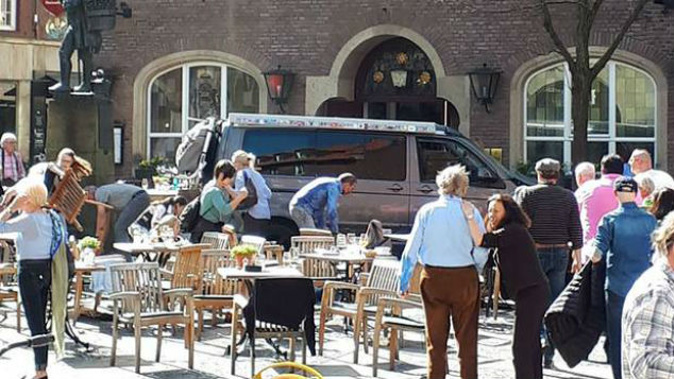 People in front of a restaurant in Münster, Germany, after a vehicle crashed into a crowd killing three. (Photo: AP)