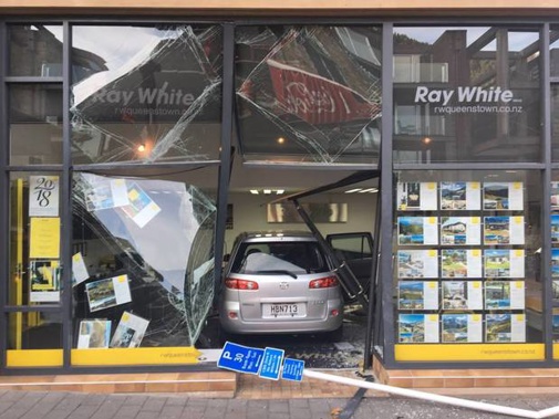The Mazda Demio after it crashed through the front door of Ray White Queenstown. (Photo / Facebook)